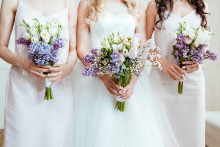 cropped shot of bride with bridesmaids holding bouquets