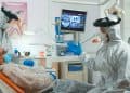 Dentist in coverall talking with woman with toothache
