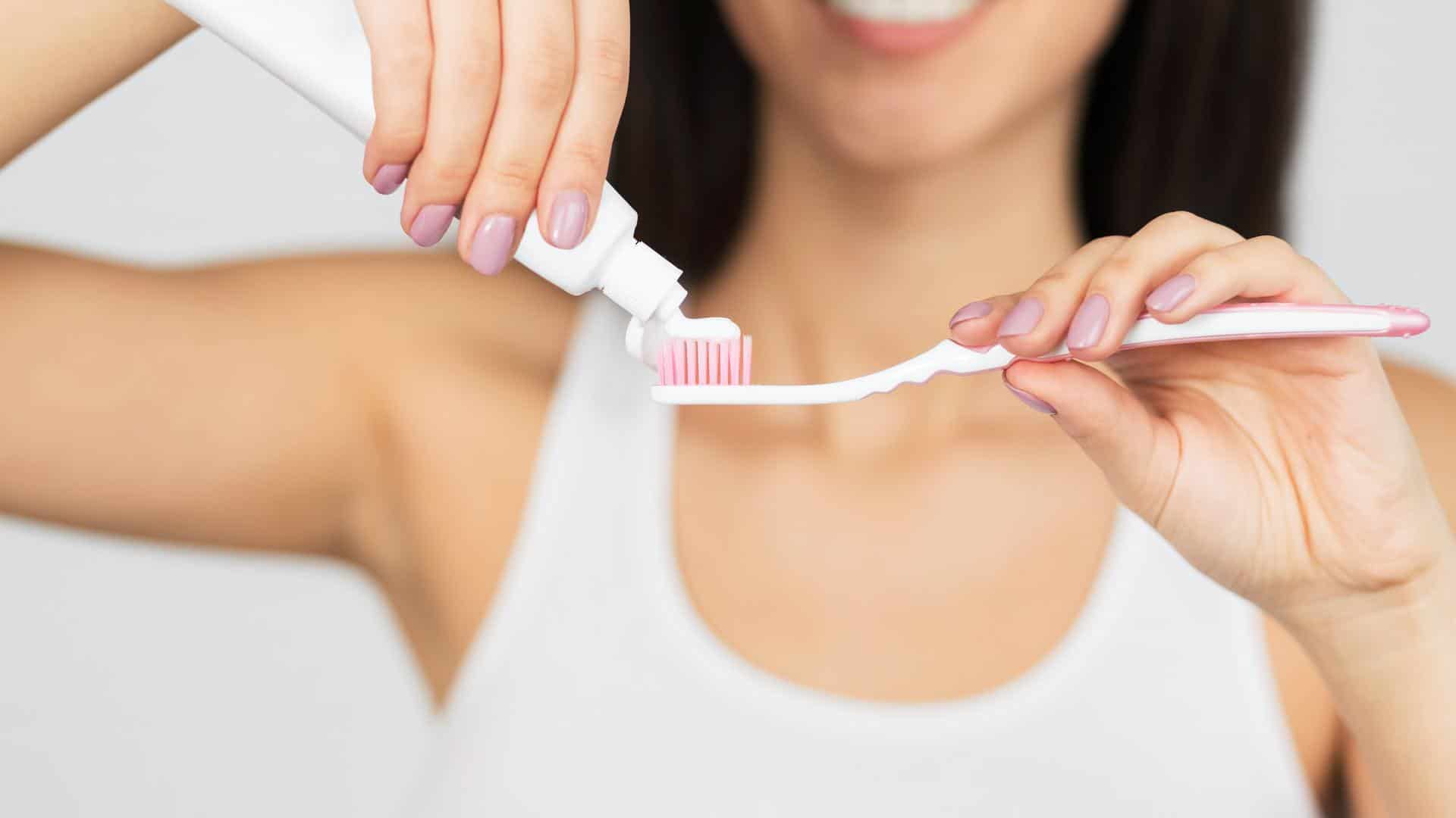 Unrecognizable Woman Putting Toothpaste On Toothbrush, White Background, Panorama